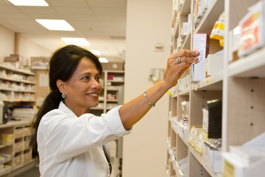 A pharmacist managing medicines and billing at a modern Indian pharmacy counter