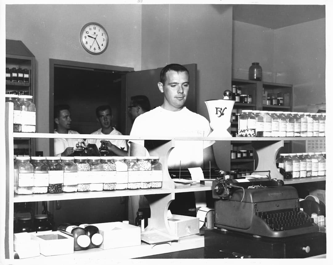 A pharmacist serving a customer at an Indian pharmacy billing counter